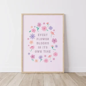 “every flower blooms in its own time” inspirational quote with floral design in pastel colours - timber frame on floor