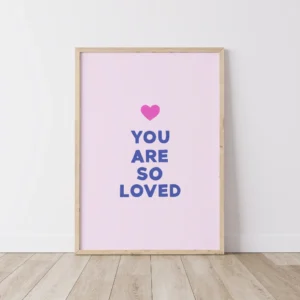 Timber framed pink print with 'You Are So Loved' message on floorboards